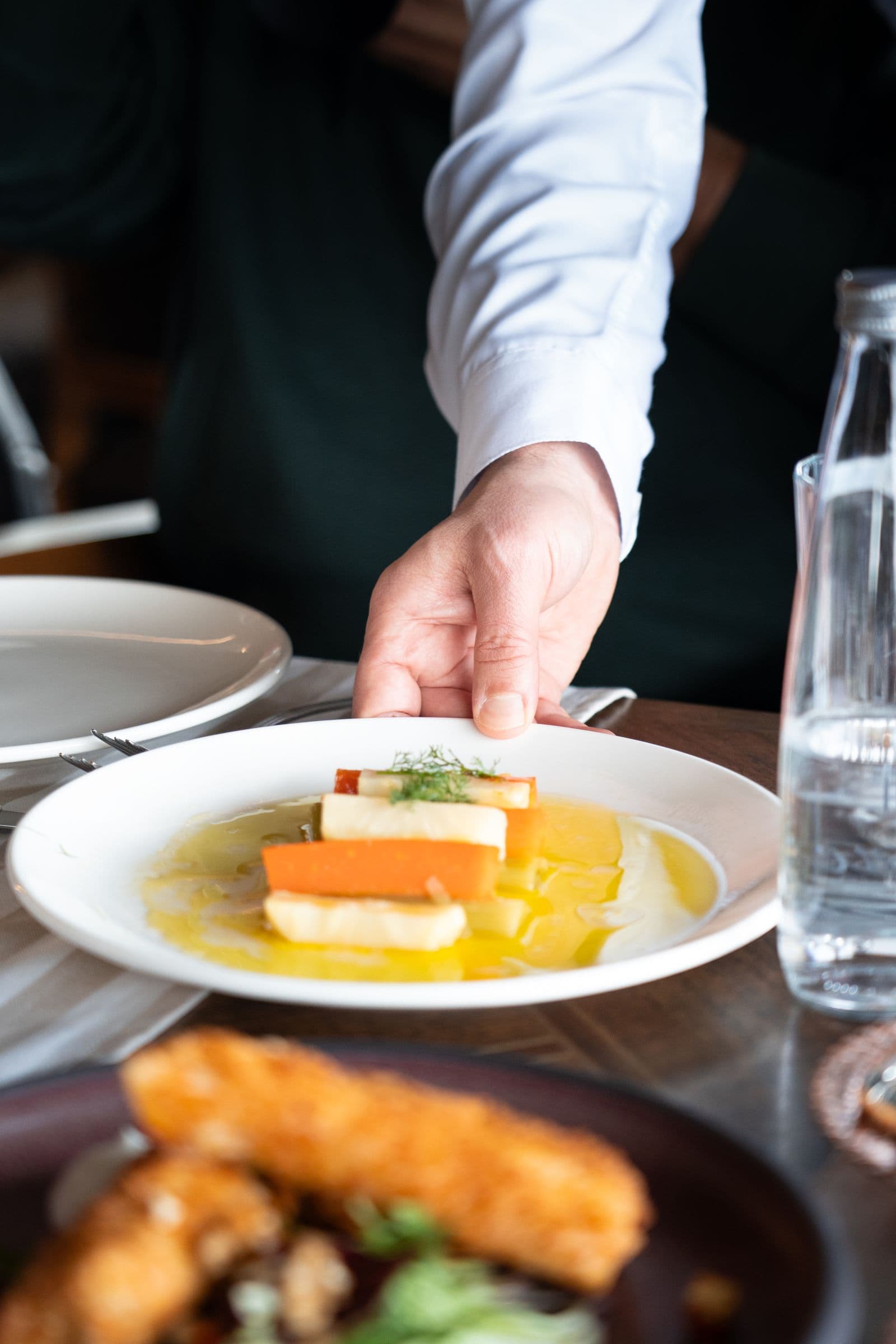 Chef placing a finished dish on a restaurant table