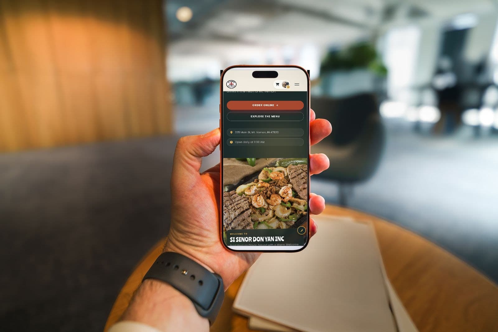 Customer holding a phone showing the Si Señor Don Yan mobile ordering page