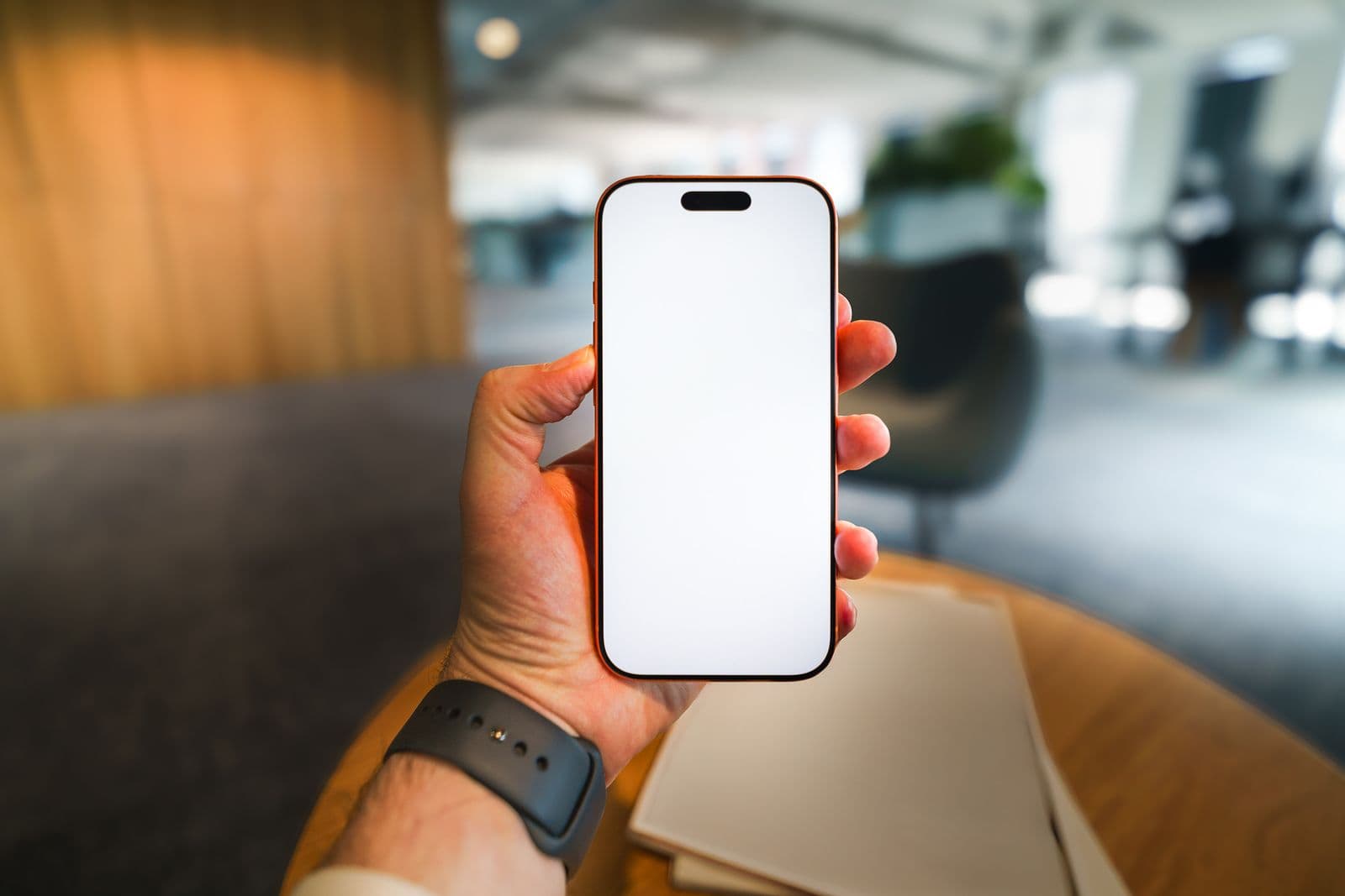 Hand holding a smartphone with a blank screen ready for a restaurant ordering experience